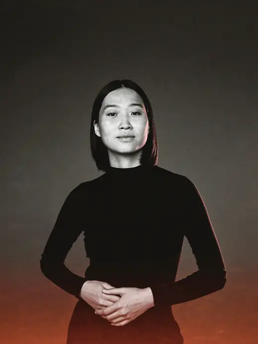 A founder in a black turtleneck, editorial black and white portrait with a warm orange glow