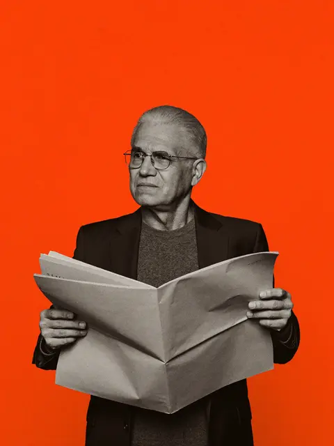 A magazine editor holding a newspaper, editorial portrait on an orange backdrop